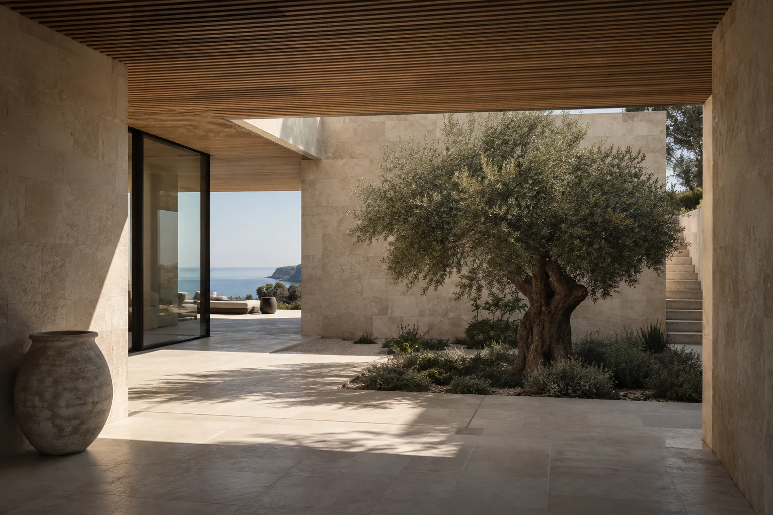 Limestone passage opening into a sunlit courtyard with an olive tree